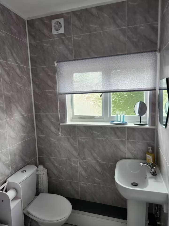 Bathroom with window, basin and tiled walls