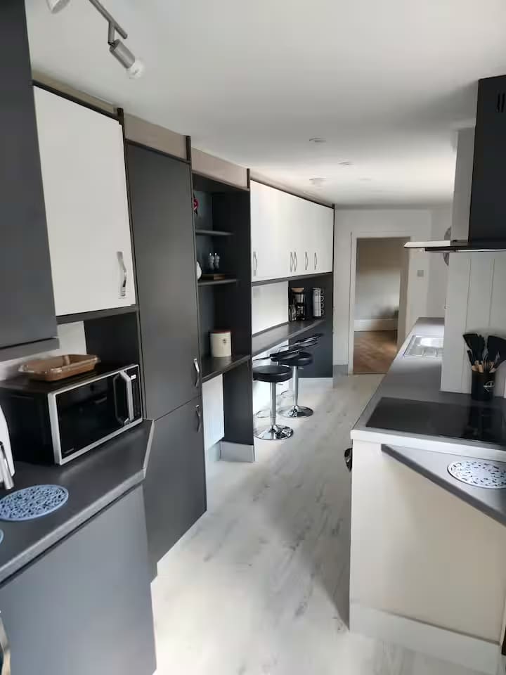 Kitchen with a breakfast bar, hob and built-in cabinets